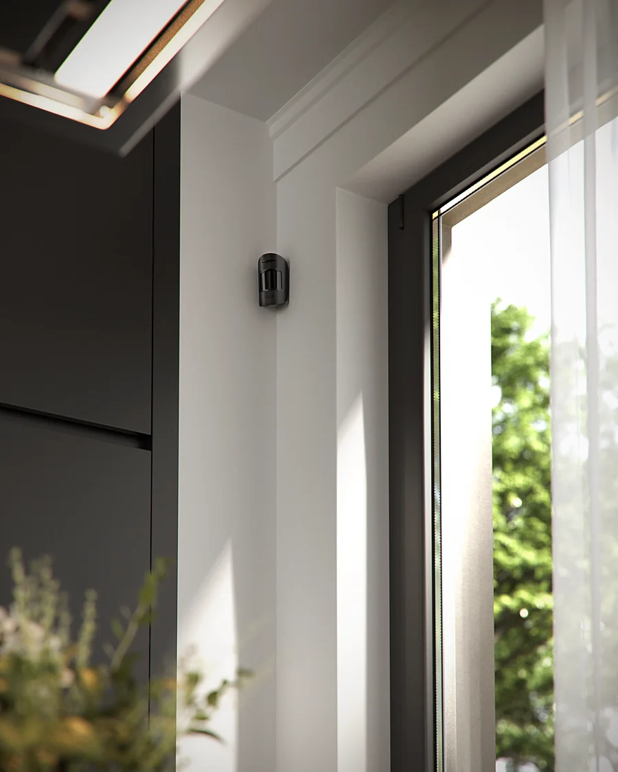 Ajax MotionProtect detector mounted beside a full-height window in a modern villa