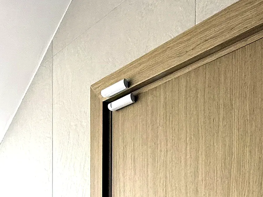 Ajax opening detector installed on an oak door frame in a villa