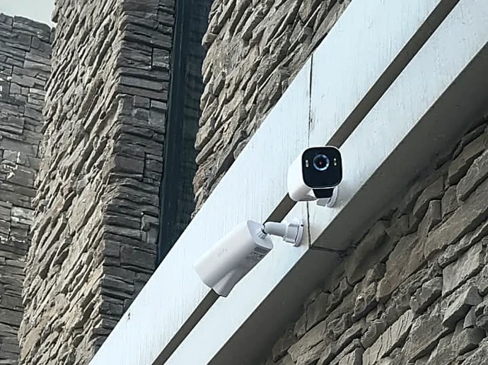 Two wireless security cameras covering a villa elevation